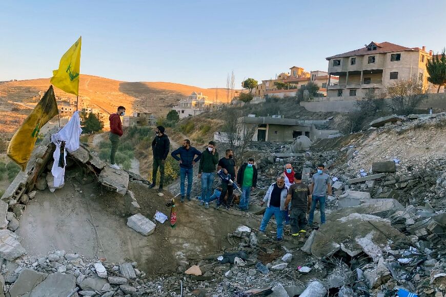 A Hezbollah flag flies as rescuers search for survivors at the site of an Israeli air strike that targeted Shmostar village in the Bekaa valley, eastern Lebanon