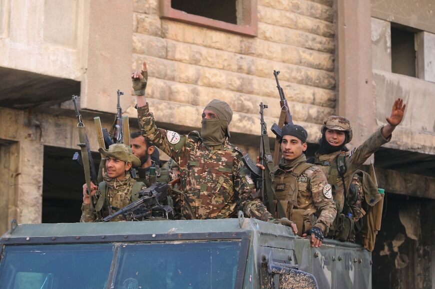 Anti-government fighters celebrate in a street in Maaret al-Numan in Syria's northwestern Idlib province on November 30, 2024