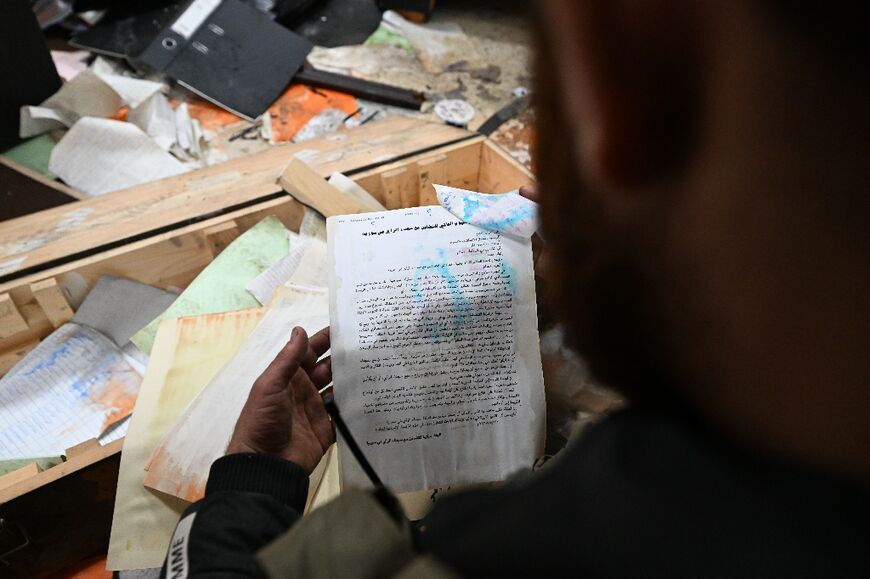 A rebel fighter reads one of the thouands files abandoned by the Assads' security services in the defence ministry complex in Damascus.