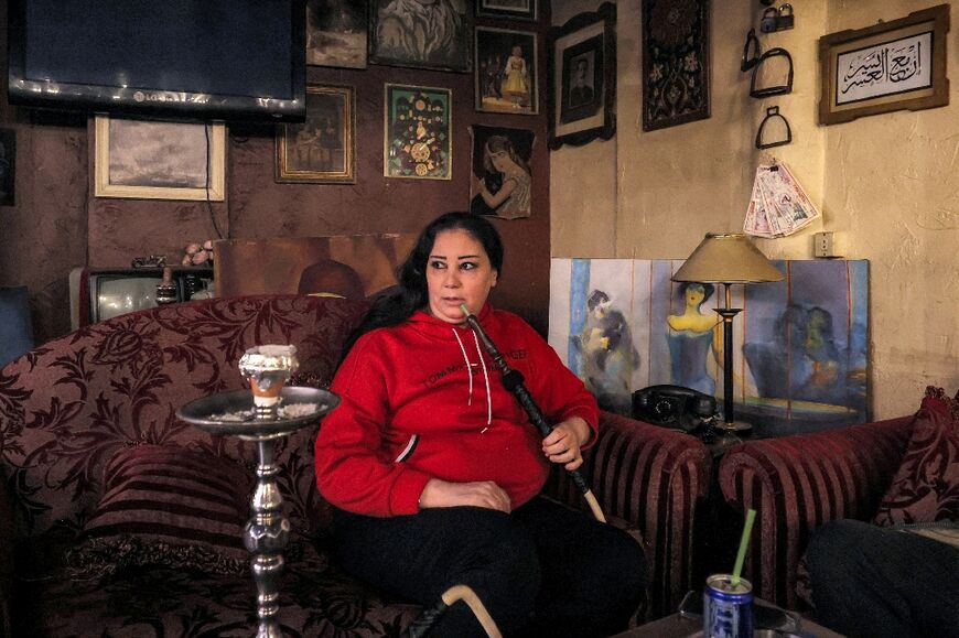 Syrian real estate agent Nesrine Shouban smokes a hookah in a cafe after being released from prison