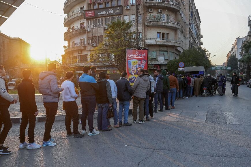 People queue for bread in rebel-held Aleppo.