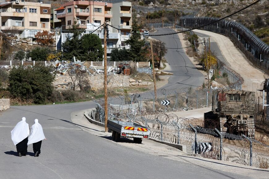 Druze women walk near the fence leading into the UN-patrolled buffer zone, which separates Israeli and Syrian forces on the Golan Heights, near the Druze village of Majdal Shams in the Israel-annexed Golan Heights on December 15, 2024