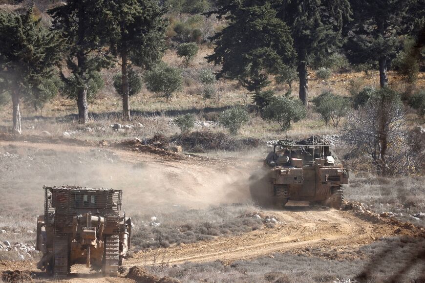 Israeli army tanks drive in the UN-patrolled buffer zone, which separates Israeli and Syrian forces on the Golan Heights, near the Druze village of Majdal Shams 