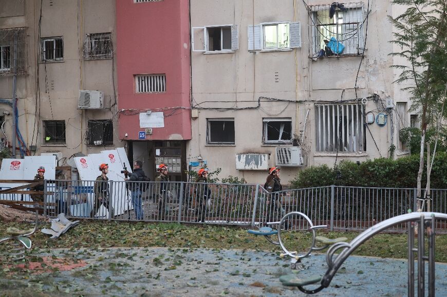 Israeli emergency responders inspect the damage at the site where a projectile fired from Yemen landed in Tel Aviv