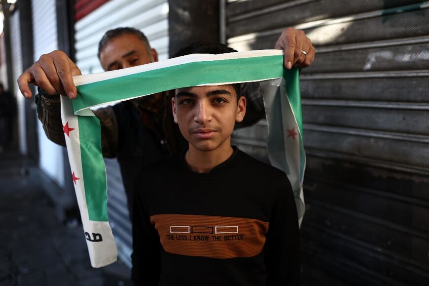 A man places a bandana of Syria's independence-era flag on a boy's head after Friday prayers in Damascus