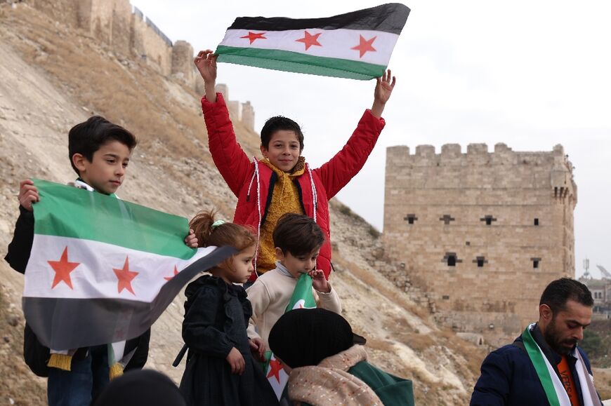 Syrian children wave the opposition flag outside Aleppo's historic citadel, captured by the rebels last weekend.