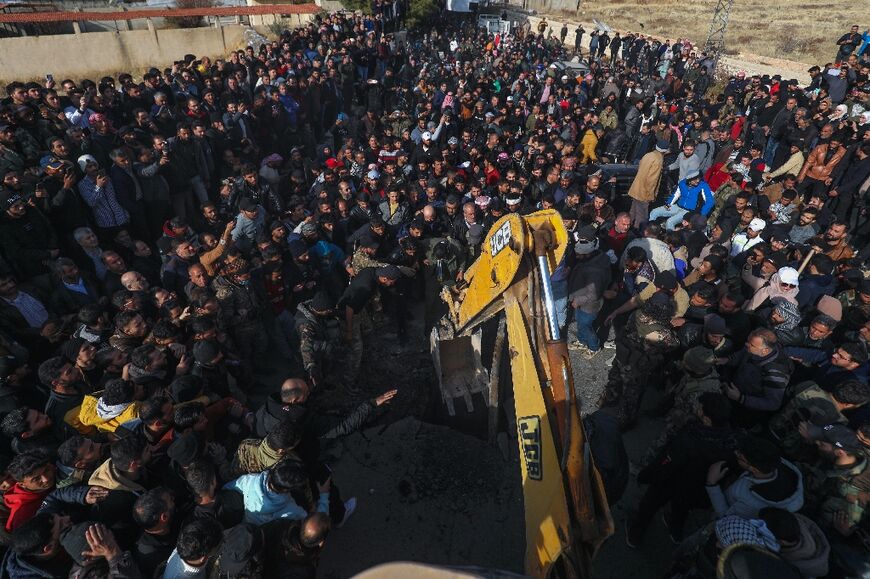 People gather as Syrian White Helmets and experts search for potential hidden basements at the Saydnaya prison