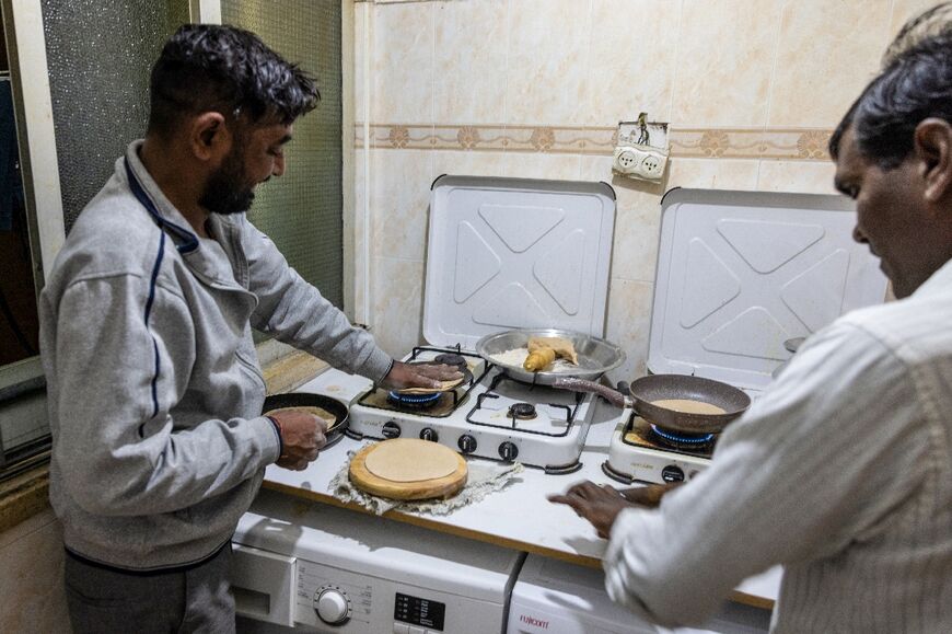 Thousands of kilometres from home, Indian construction workers prepare a meal at their flat in the Israeli coastal city of Tel Aviv 