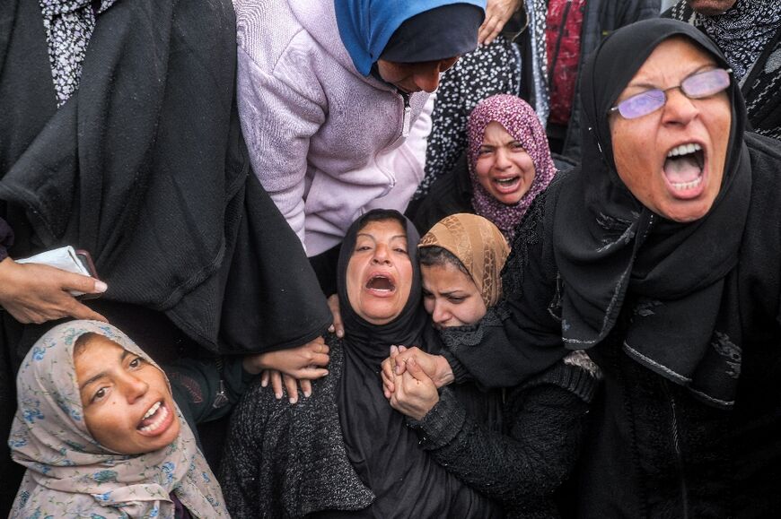 Women at a hospital in Deir el-Balah, central Gaza, mourn relatives killed by Israeli bombardment 