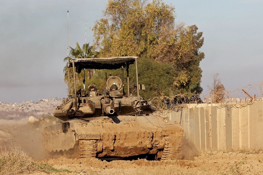 An Israeli tank drives into position near Israel's southern border with the Gaza Strip on January 14, 2025