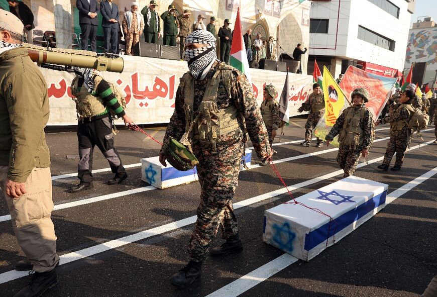 Some dragged coffins decorated with Israeli flags, as flags of Hezbollah flew along with Iranian and Palestinian banners