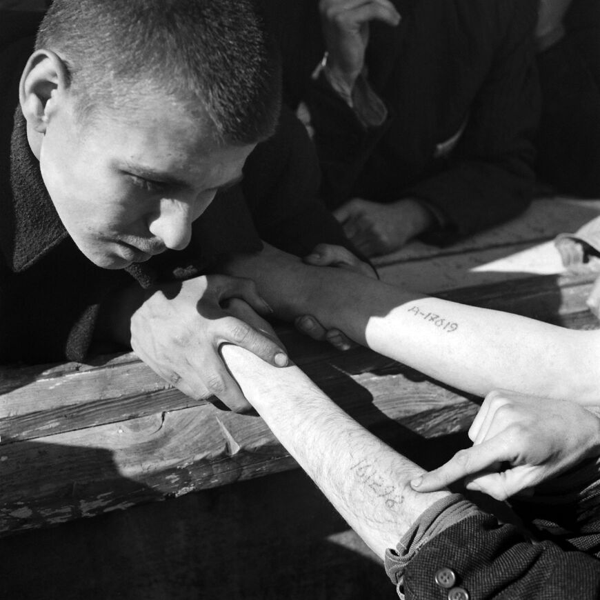 Polish Jews show the prisoner numbers tattooed on them at Auschwitz