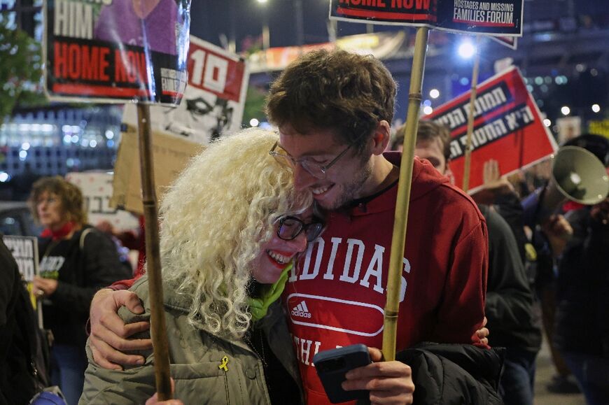 Demonstrators at a protest calling for action to free Israeli hostages in Gaza embrace after a deal is announced