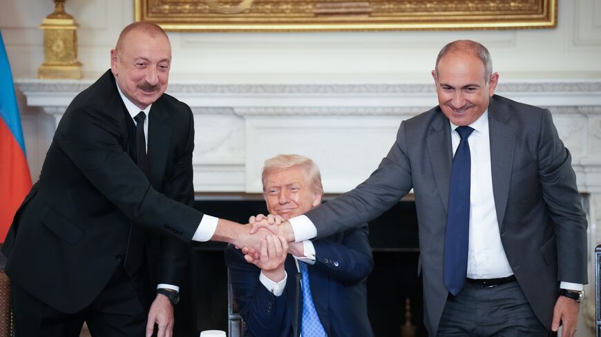 US President Donald Trump (C) joins hands with Azerbaijani President Ilham Aliyev (L) and Armenian Prime Minister Nikol Pashinyan (R) during a signing ceremony in the State Dining Room of the White House, Washington, DC, Aug. 8, 20
